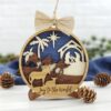Christmas Ornaments 3D 5" Round Wood Nativity Ornament with 4 layers. Front Layer: Donkey and Lamb. Second Layer: Wise Men on Camels. Third Layer: Palm Trees, Star, Nativity Scene. Back Layer: Dark Blue. Sparkly Burlap Ribbon with wood bead and Jute twine hanger.